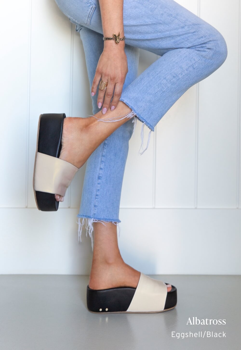 Woman wearing Albatross leather platform sandals in eggshell/black with jeans.