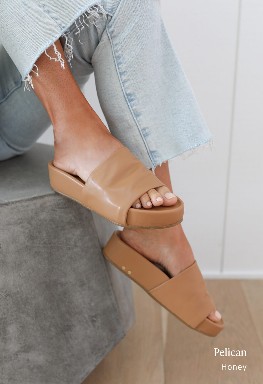 Woman wearing Pelican leather platform sandals in honey with jeans