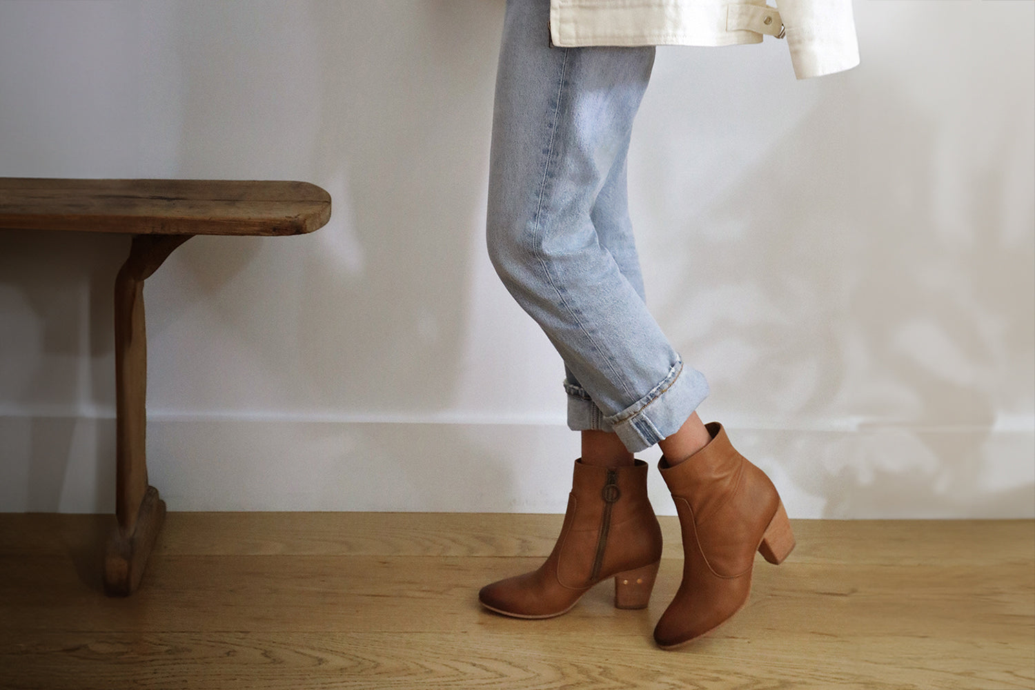 Woman wearing Catbird leather boots in tan with jeans and cream jacket