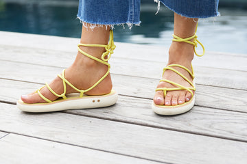 Woman wearing Chirp leather ankle wrap sandals in citrus with jeans