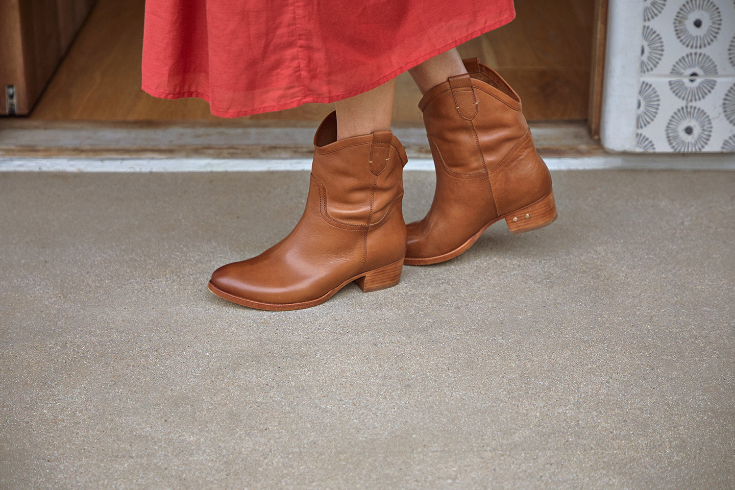 Woman wearing Condor leather boots in tan with red dress