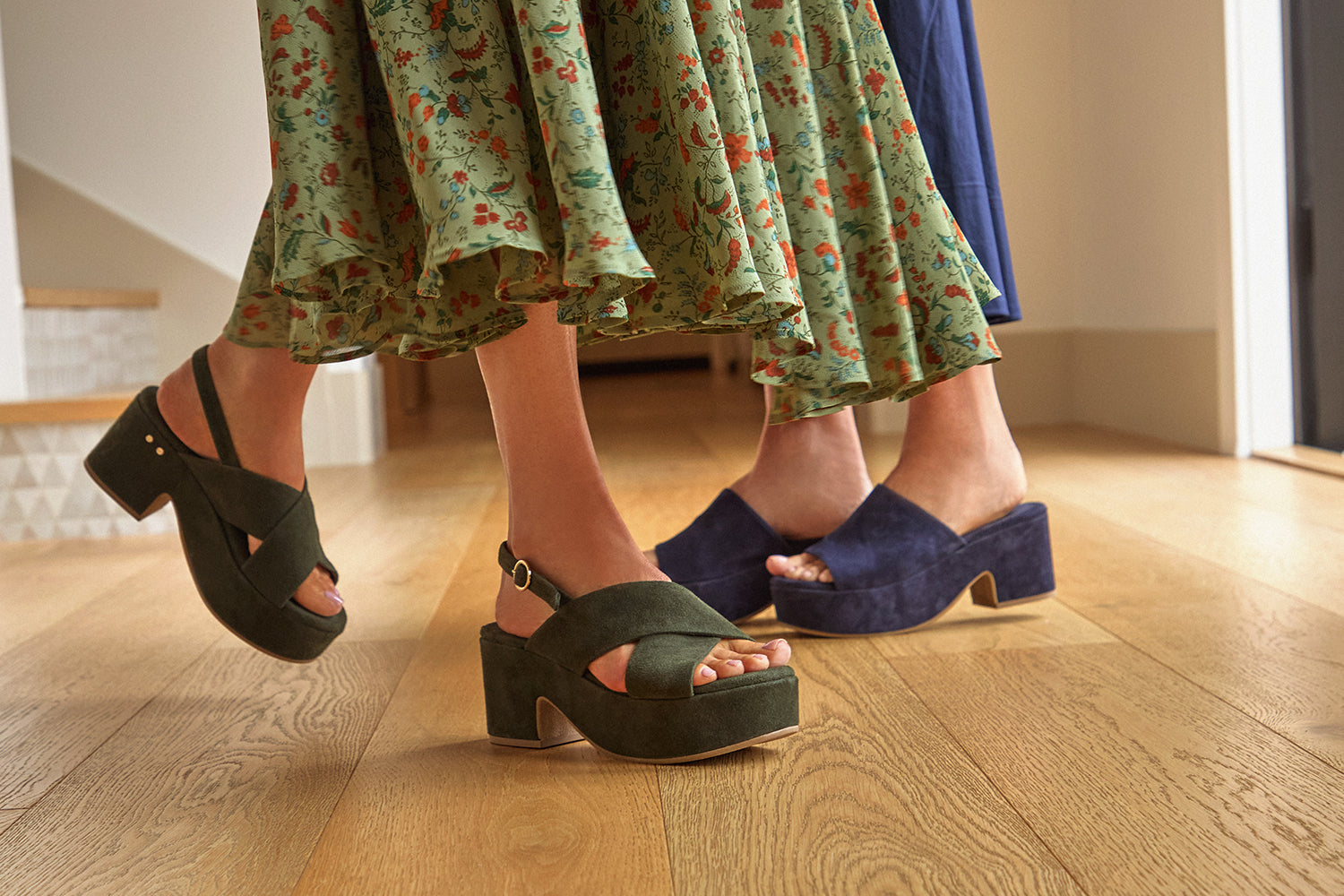 Women wearing Dunlin suede crossover strap platform heeled sandals in ivy and Kinglet suede heeled sandals in navy.