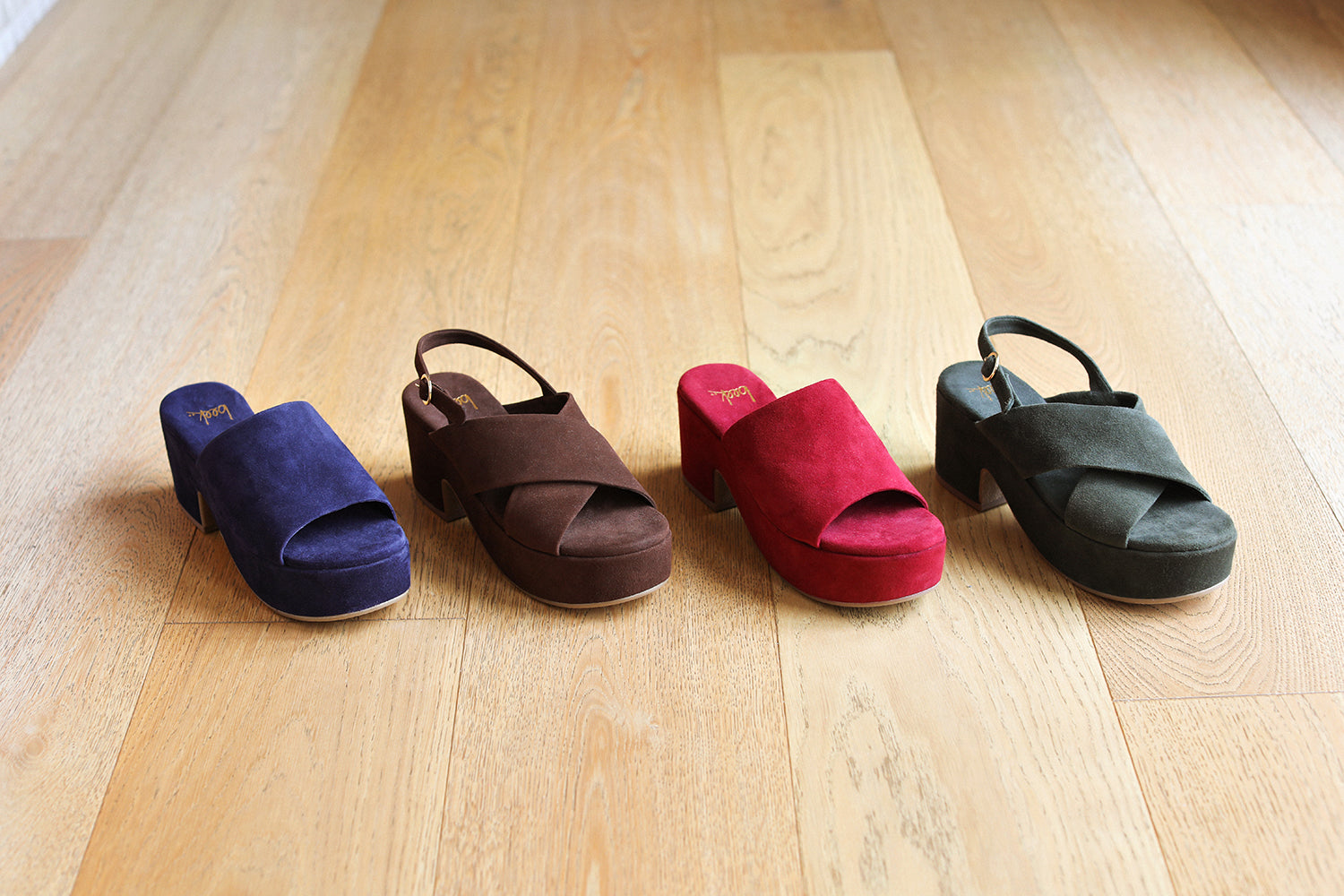 Group shot of Kinglet suede heeled sandals in navy and port with Dunlin suede heeled sandals in coffee and ivy.