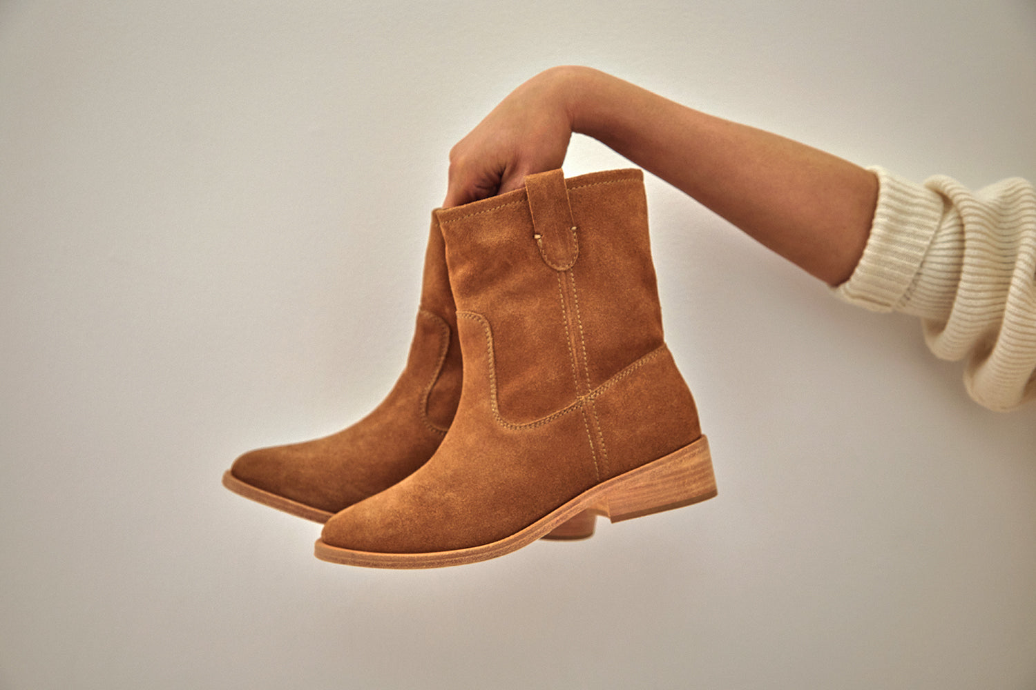 Woman holding Grouse suede boots in chestnut