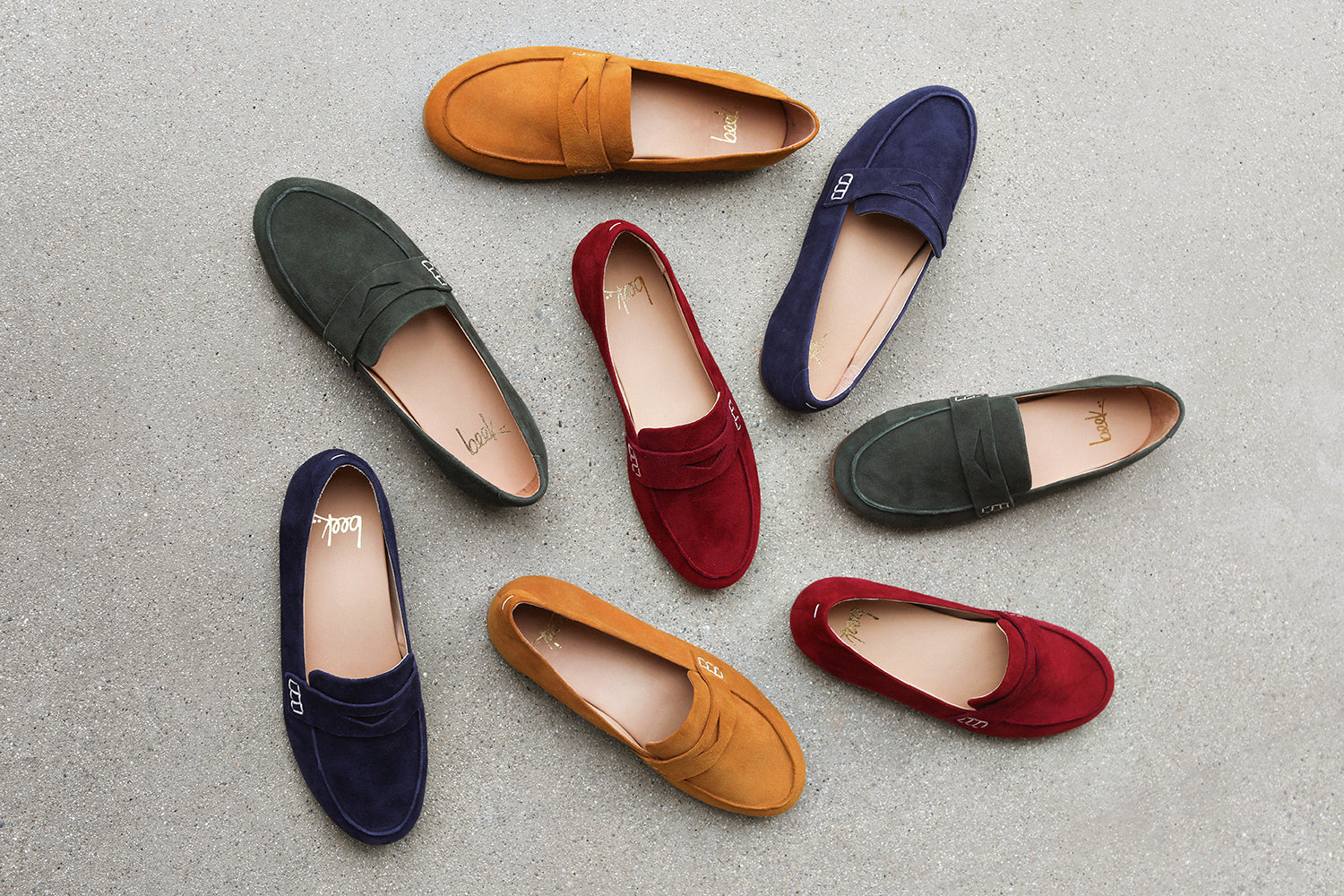 Scattered group shot of Moorhen suede loafers in caramel, navy, ivy, port.
