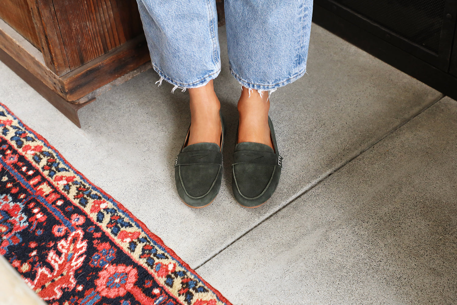 Woman wearing Moorhen suede loafers in ivy with jeans