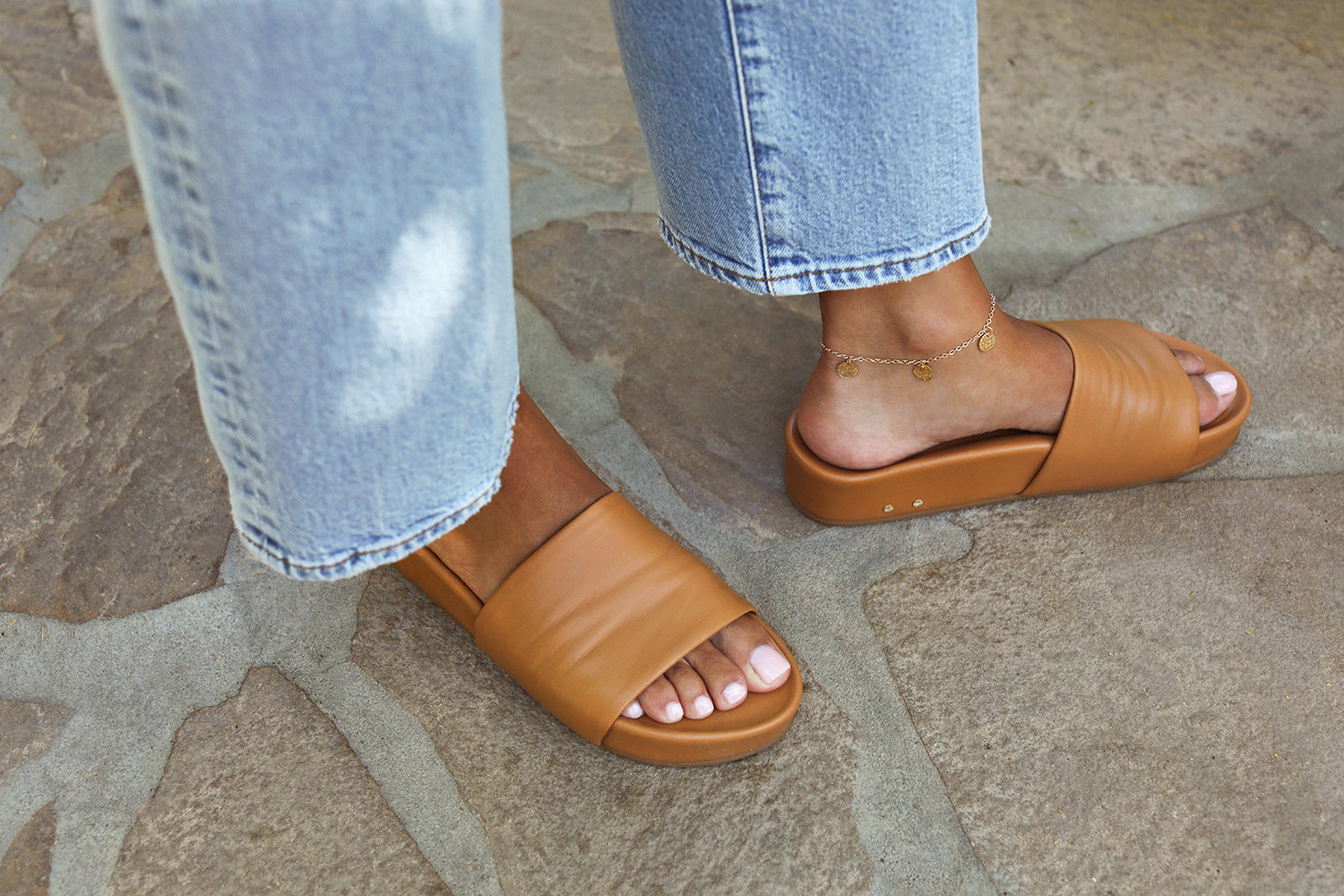 woman wearing Pelican leather platform slide sandals in honey with jeans