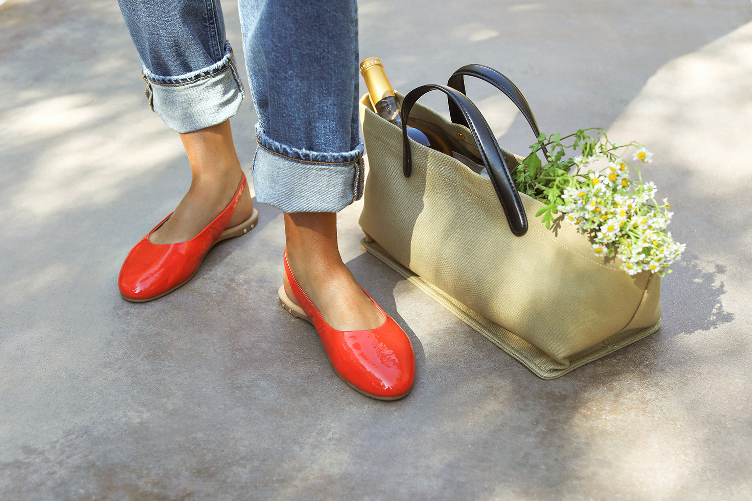 Woman wearing Pipit patent leather ballet mules in tomato