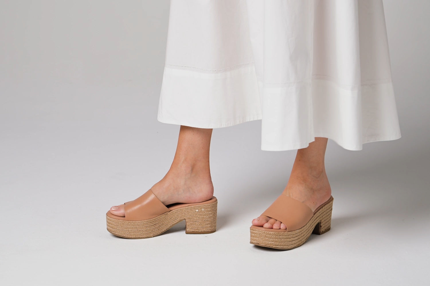 Woman wearing Prinia Jute leather heeled sandals in beach with white dress