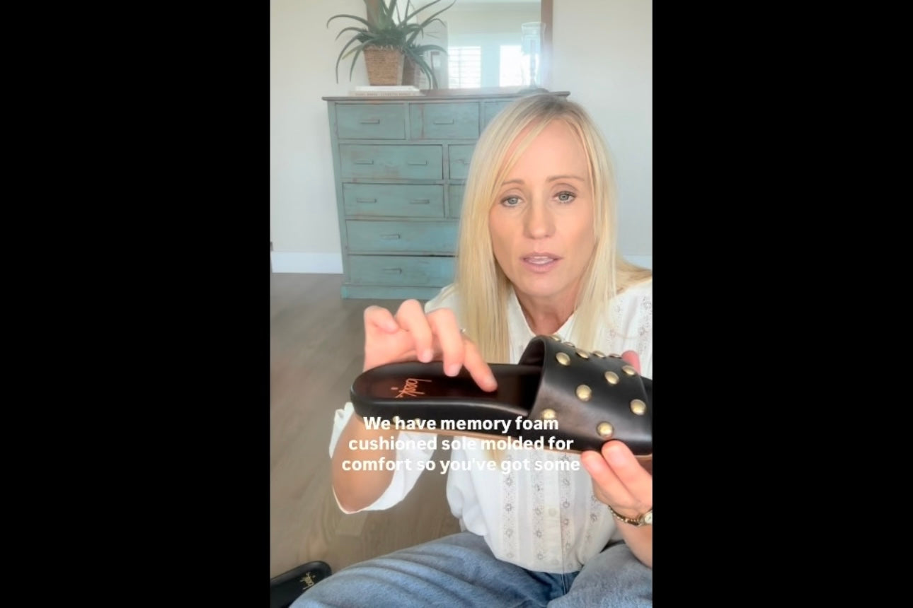 Video of Kenna, co-founder of beek, trying on and talking about Gallito Stud leather slide sandal in black in size 8 and 9. Captions included.