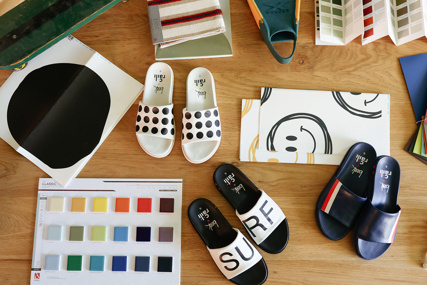 Group shot of Railibird leather slide sandals in dot, surf, and stripe on interior designer work table