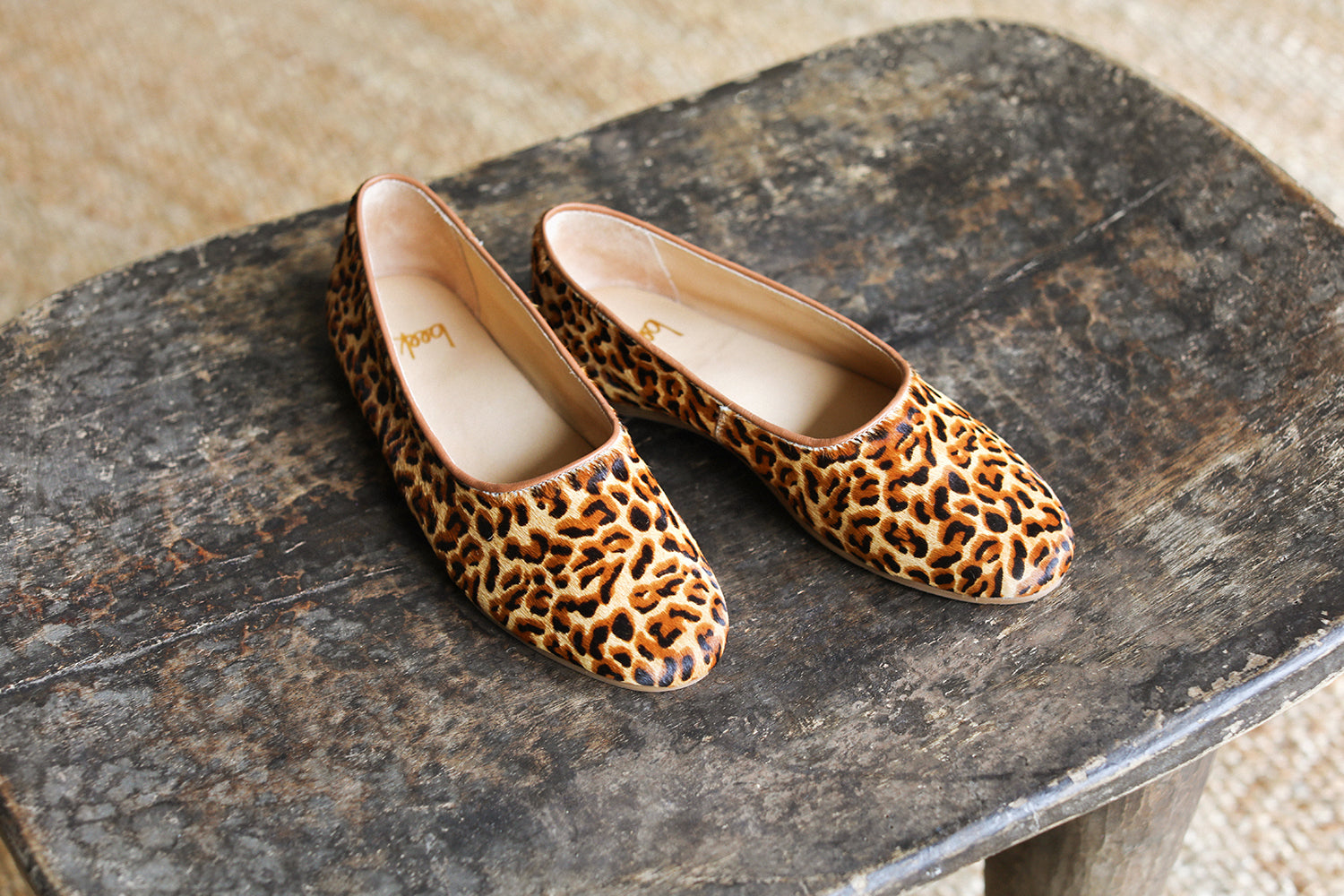 Swiftlet calf-hair and leather ballet slipper in leopard on dark stone surface