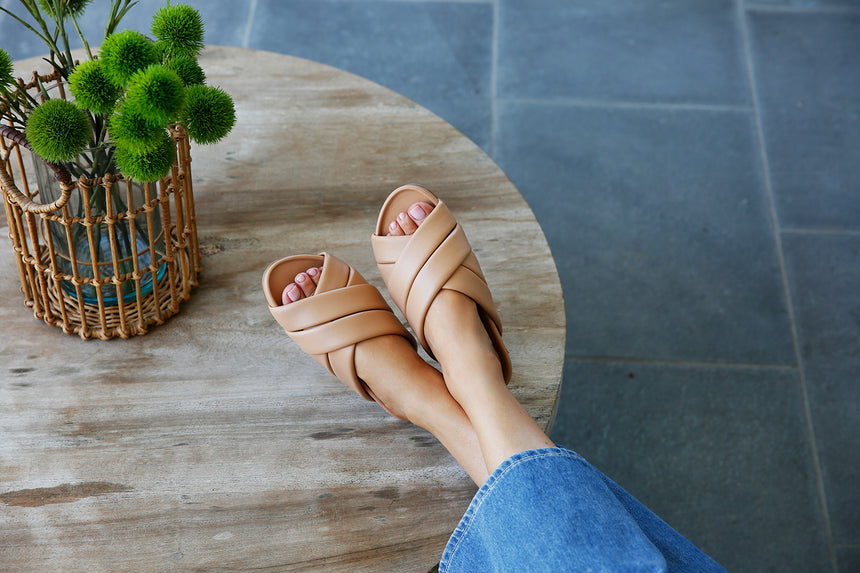 Woman wearing Merlin leather sandals in beach.