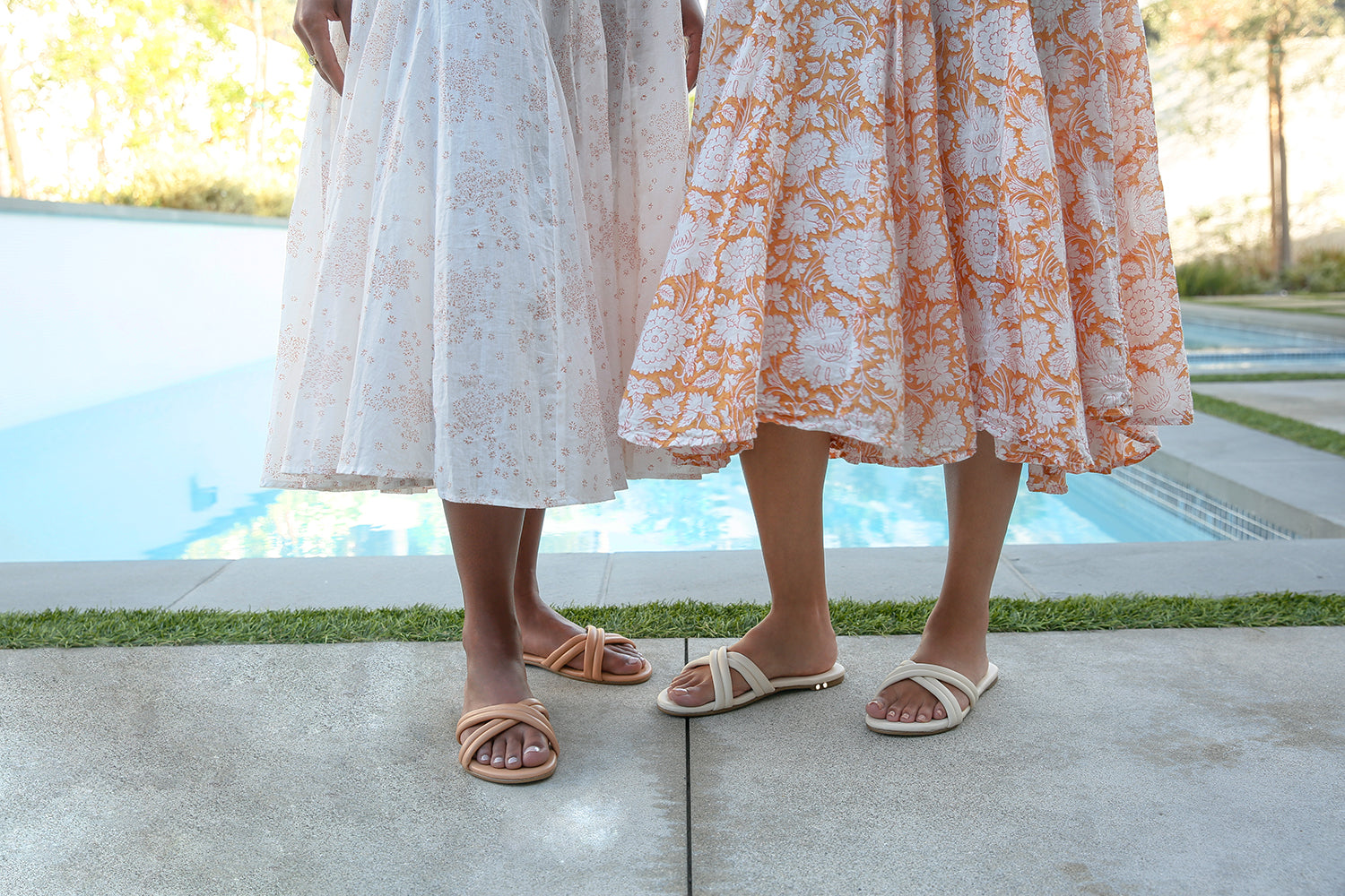 Women wearing bellbird sandals in beach and eggshell.
