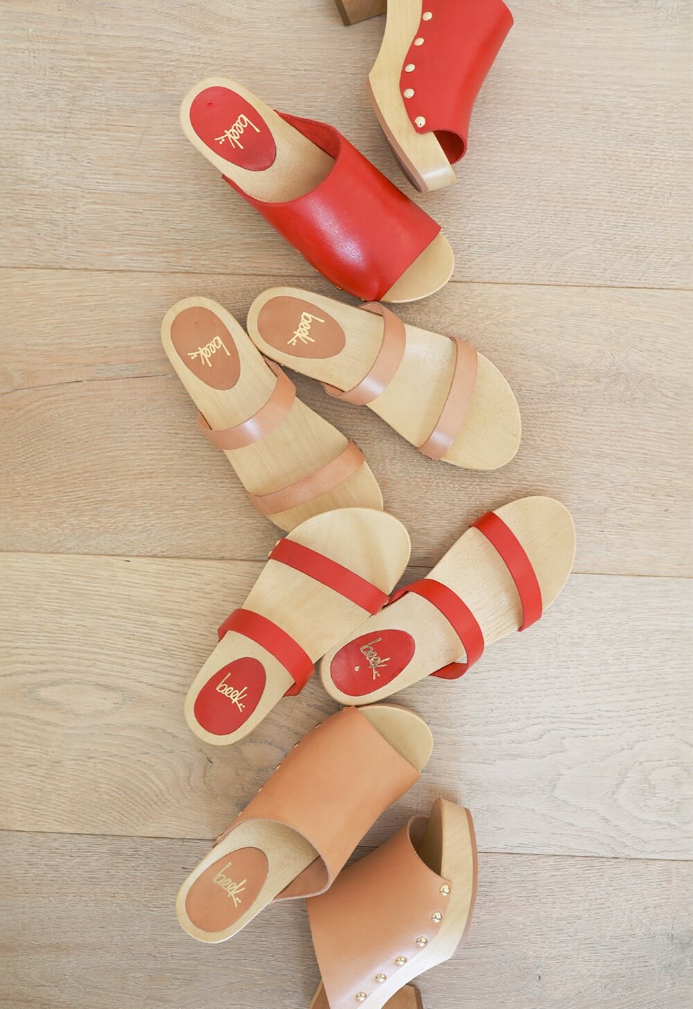 Group shot of Peacock clogs in honey and red with Dipper clogs in red and honey.