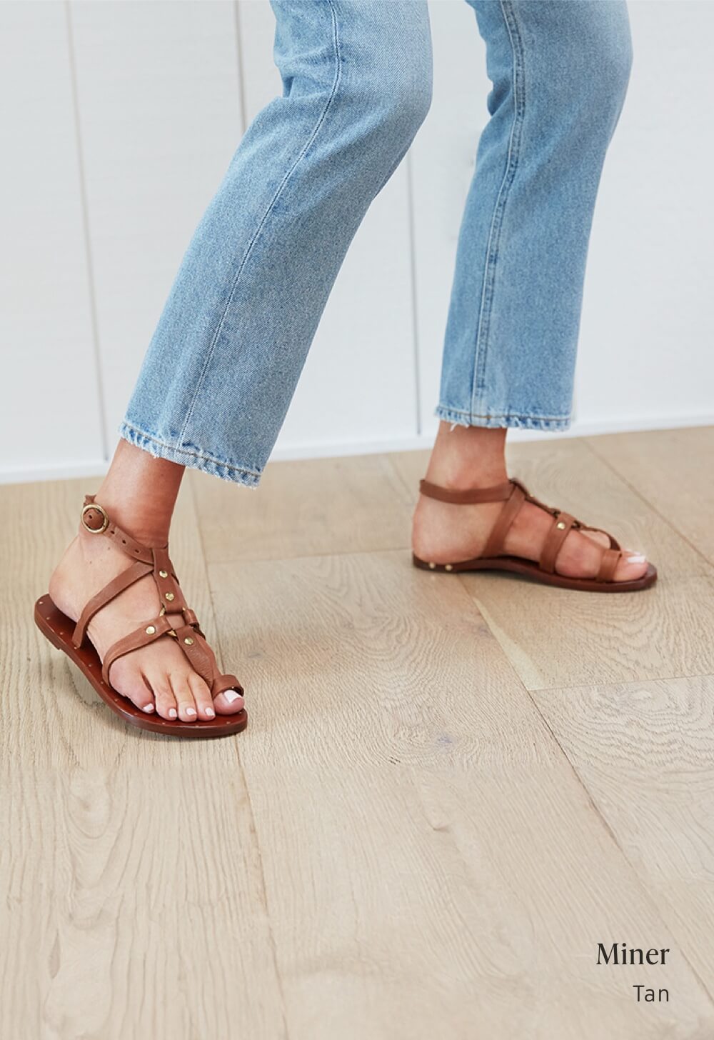 Woman wearing Miner toe ring ankle strap sandals in tan with jeans.