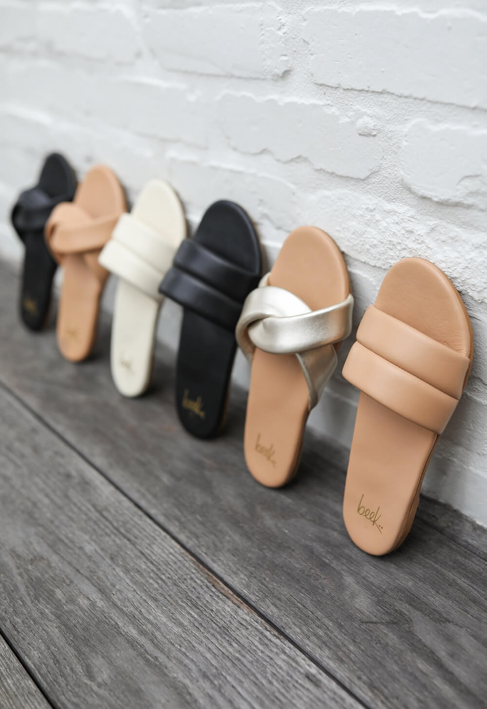 Group shot of Twistybird sandals in black, beach, platinum/beach with Sugarbird slide sandals in eggshell, black, beach.