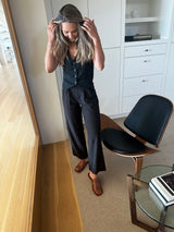 Alicia from @lifestyle_wifestyle wearing Broadbill leather mules in cognac with black slacks and vest..