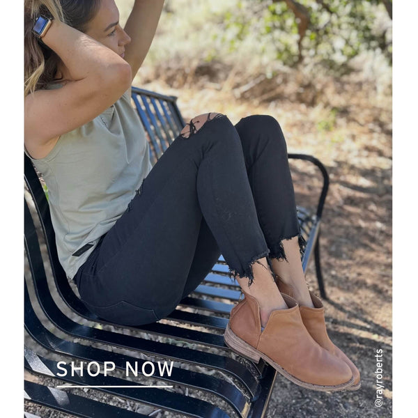 Influencer @rayroberts wearing Falcon leather boots in cognac with black jeans and beige tank top.