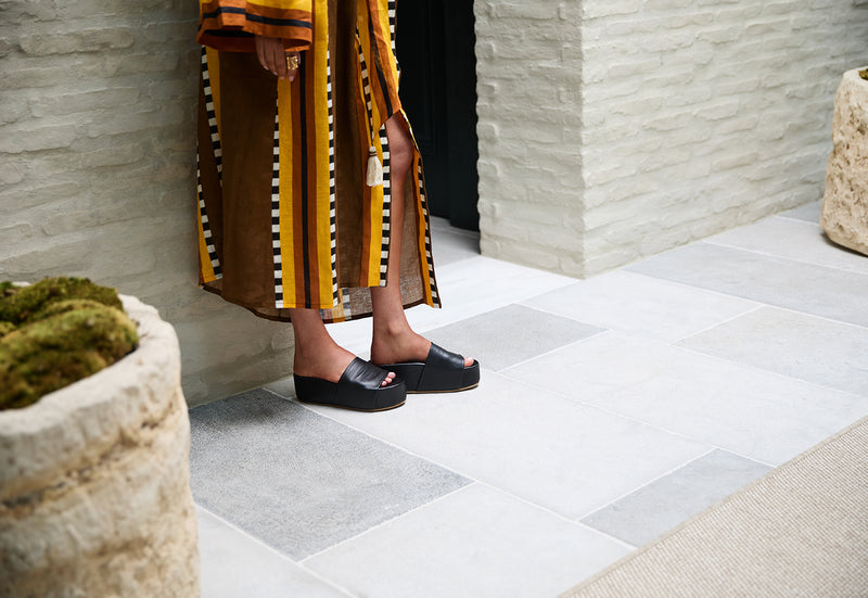 Woman wearing Albatross leather platform sandal in black with patterned dress