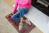 Woman wearing Alpine Swift shearling and suede booties in stone with jeans and pink sweater.