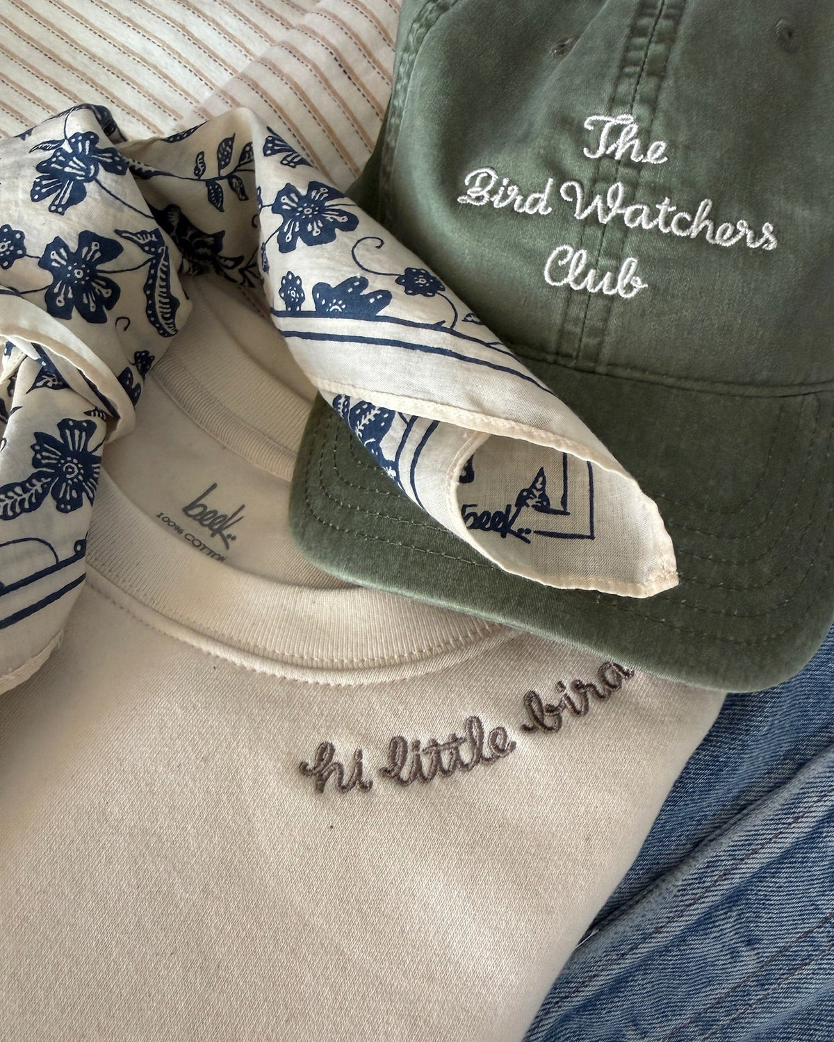 beek merch: pixie scarf in navy, bird watchers hat in fern, little bird sweatshirt in vintage white
