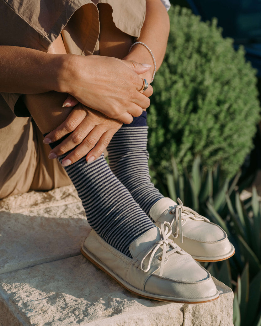 Woman wearing Boatbird leather loafers in vanilla with striped socks, beige pants
