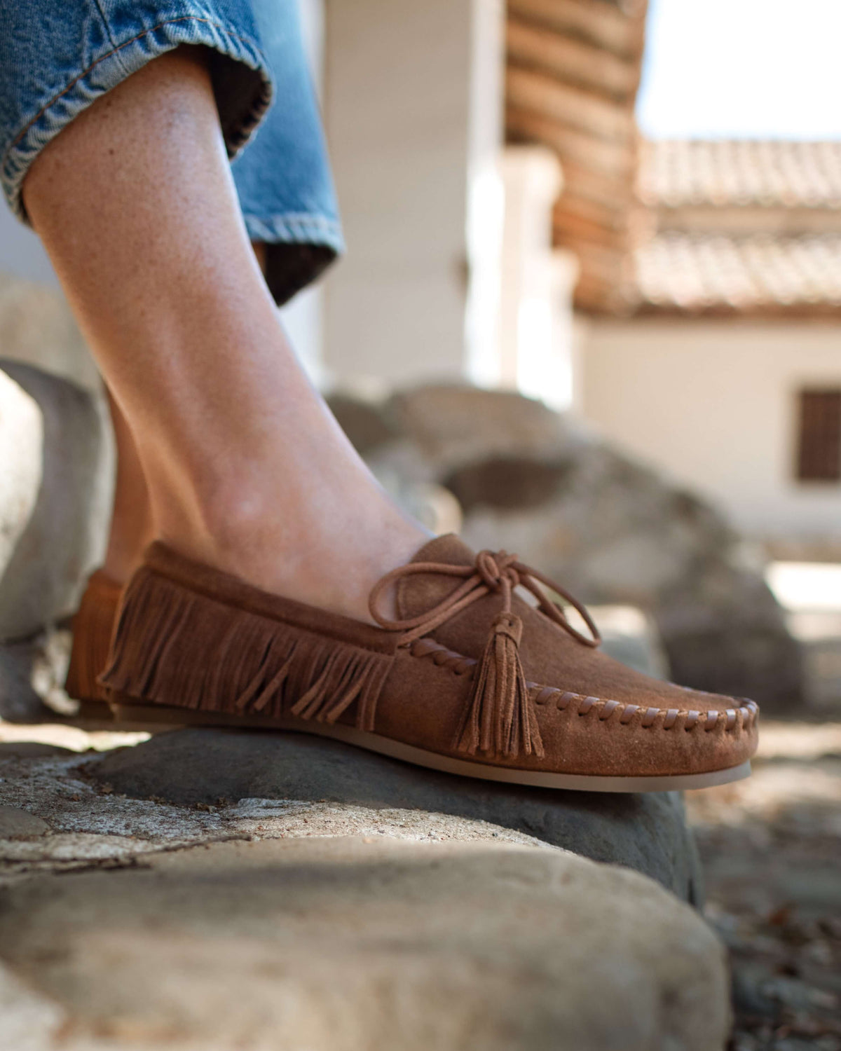 Woman wearing Burke suede moccasin shoe in chestnut with jeans