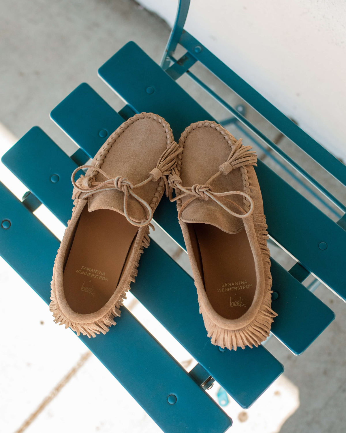 Burke suede moccasin shoe in oat lay down shot on teal chair