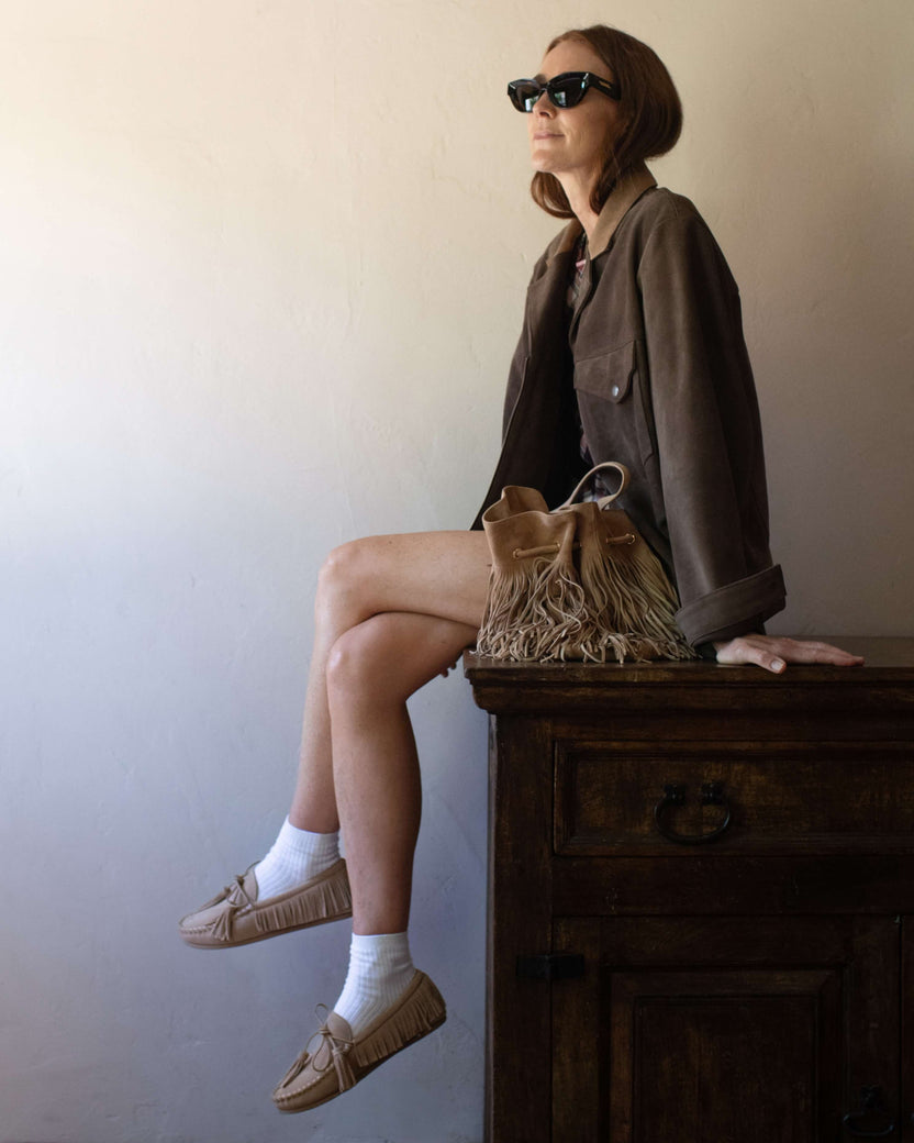 Samantha Wennerstrom wearing Burke suede moccasin shoe in oat  withcoat and fringed suede purse