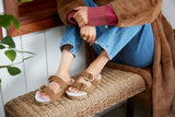 Woman wearing Buzzard shearling sandals with two ring adjustable strap in chestnut.
