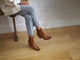 Woman wearing Catbird leather boots in tan with jeans and cream jacket
