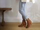 Woman wearing Catbird leather boots in tan with jeans and cream jacket