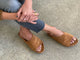 Woman wearing Group shot of Kea suede slide sandals in caramel with jeans