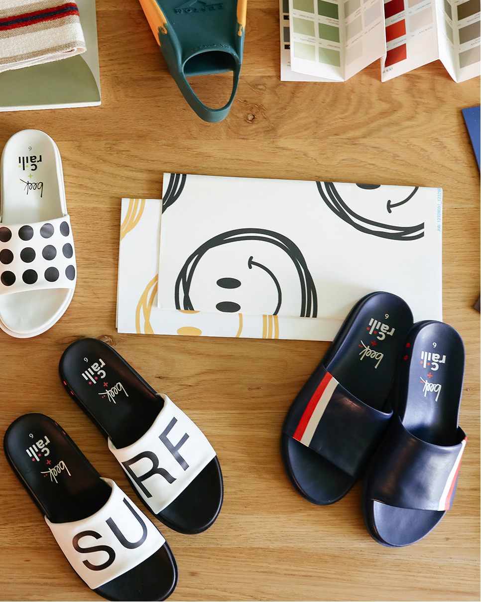 Group shot of Railibird leather slide sandals in dot, stripe, and surf on interior designer work table