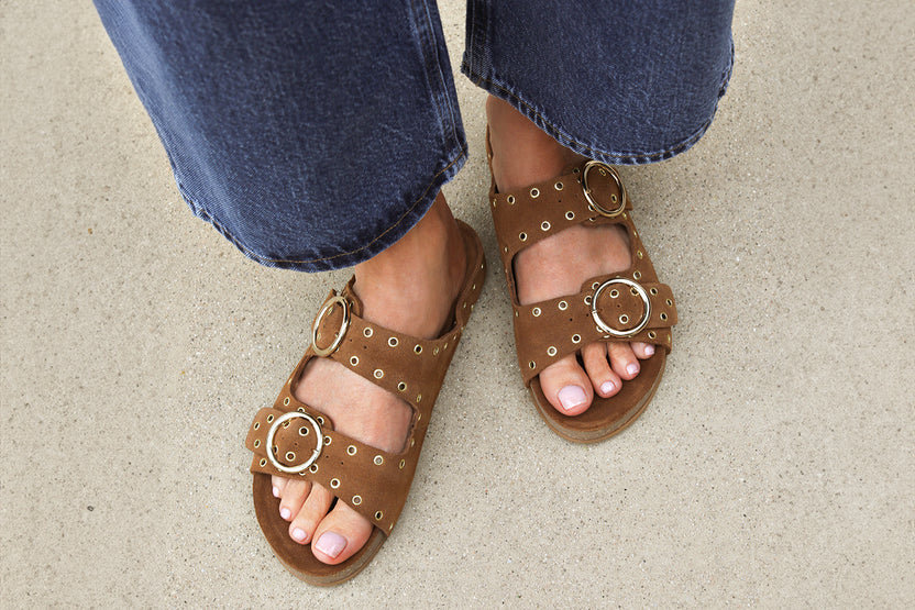 Woman wearing Cedar suede slide sandal in chestnut with jeans