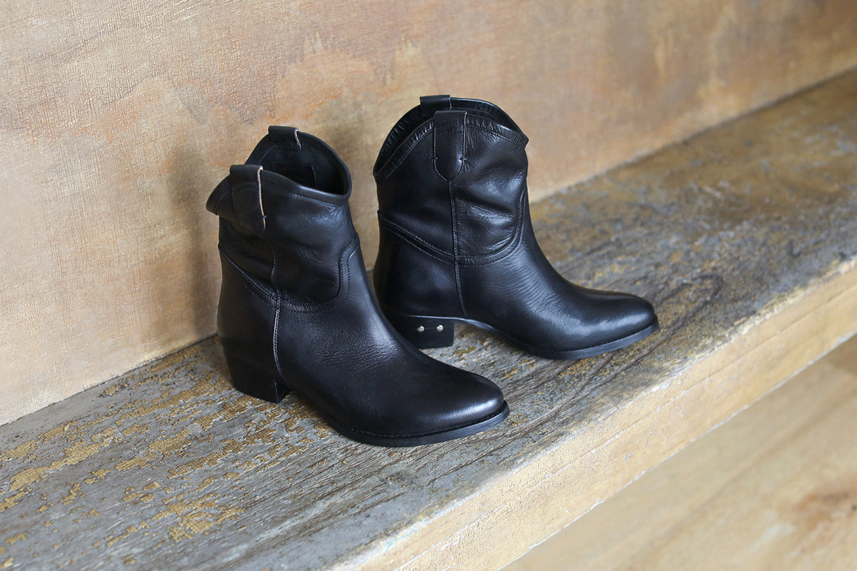 Condor leather boots in black on wooden ledge