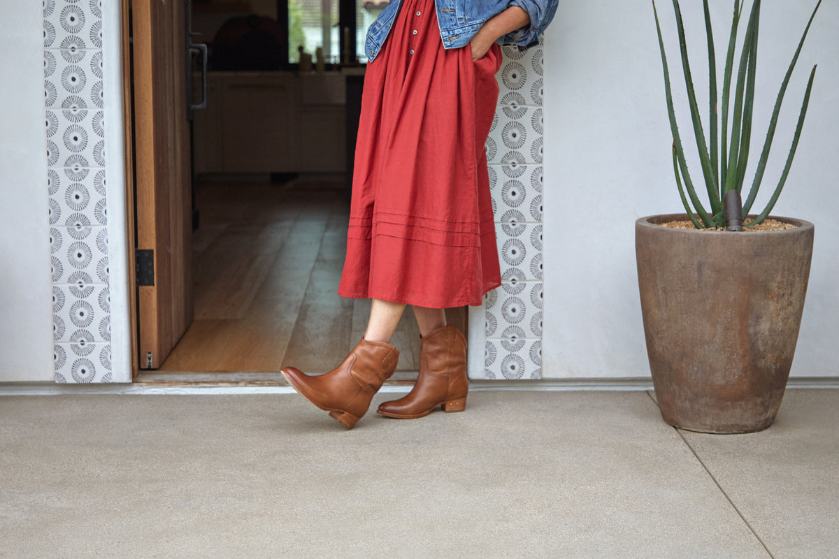 Woman wearing Condor leather boots in tan with red dress and jean jacket