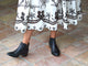Woman wearing Cowbird leather ankle boots in black with white embroidered dress