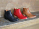 Group shot of Cowbird leather ankle boots in black, red, and tan