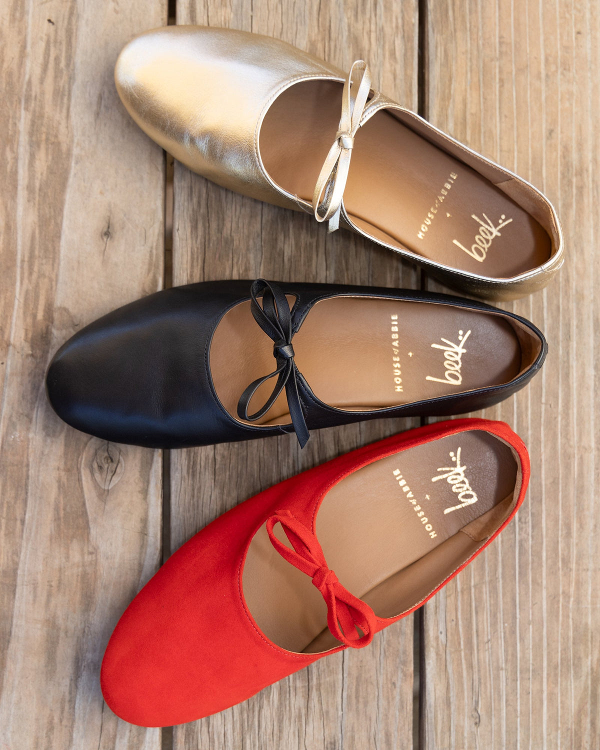 Group shot of Crane Bow leather mary jane shoes in gold, black, poppy