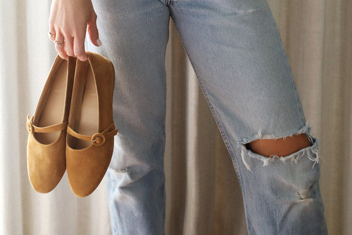 Woman carrying Crane suede mary jane shoe in caramel wearing distressed jeans
