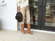 Woman wearing Crow tall leather boots in tan with beige pants and sweater