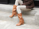 Woman wearing Crow tall leather boots in tan with beige pants and c jacketplaid
