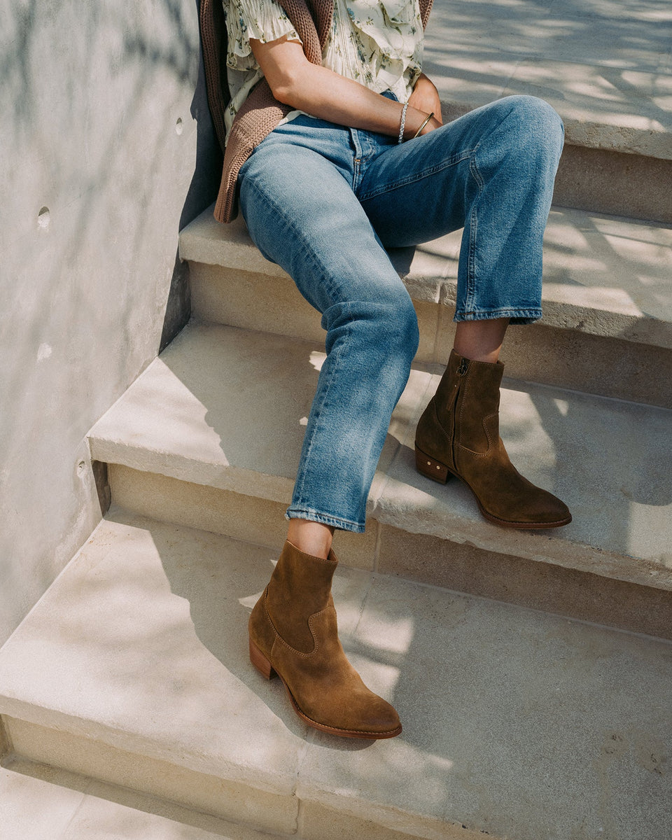 Woman wearing Cuervo suede boots in chestnut with jeans sitting on steps
