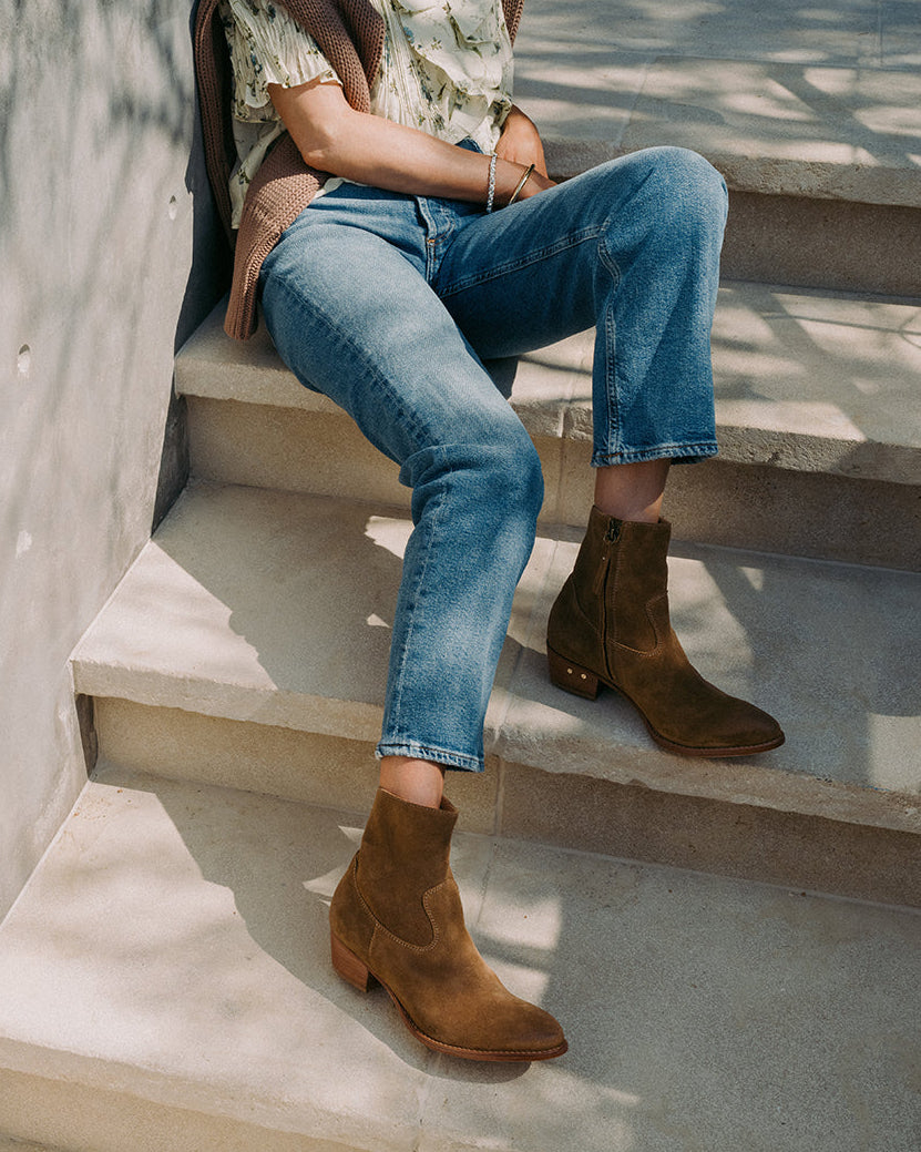Woman wearing Cuervo suede boots in chestnut with jeans sitting on steps