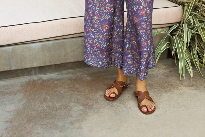 Woman wearing Curlew leather studded toe-ring sandal in tan