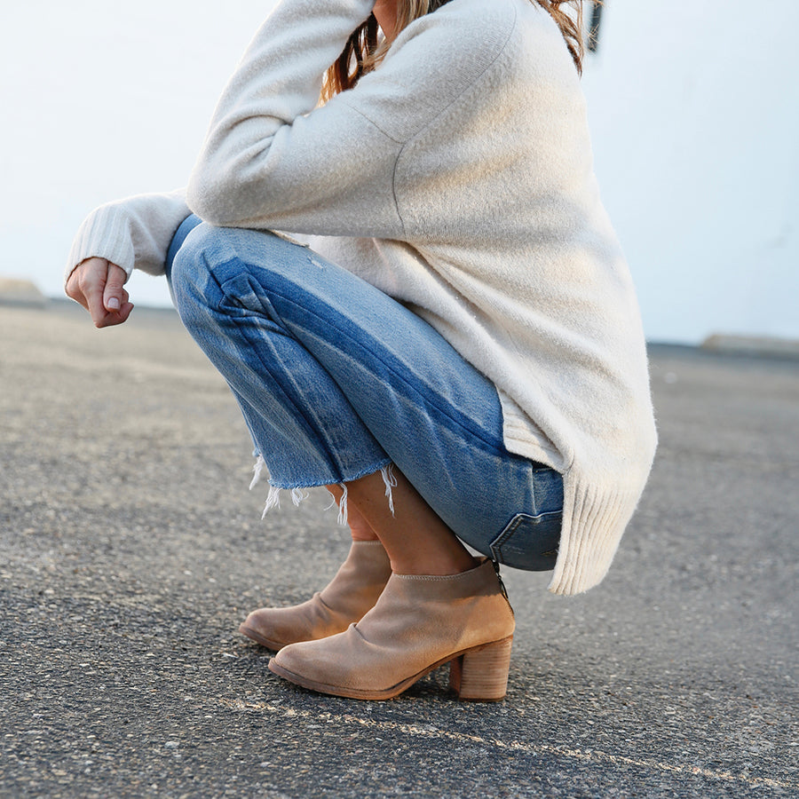 Woman wearing Eaglet suede booties in stone with jeans and sweater.