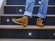 Woman wearing Falcon suede booties in chestnut with jeans on steps