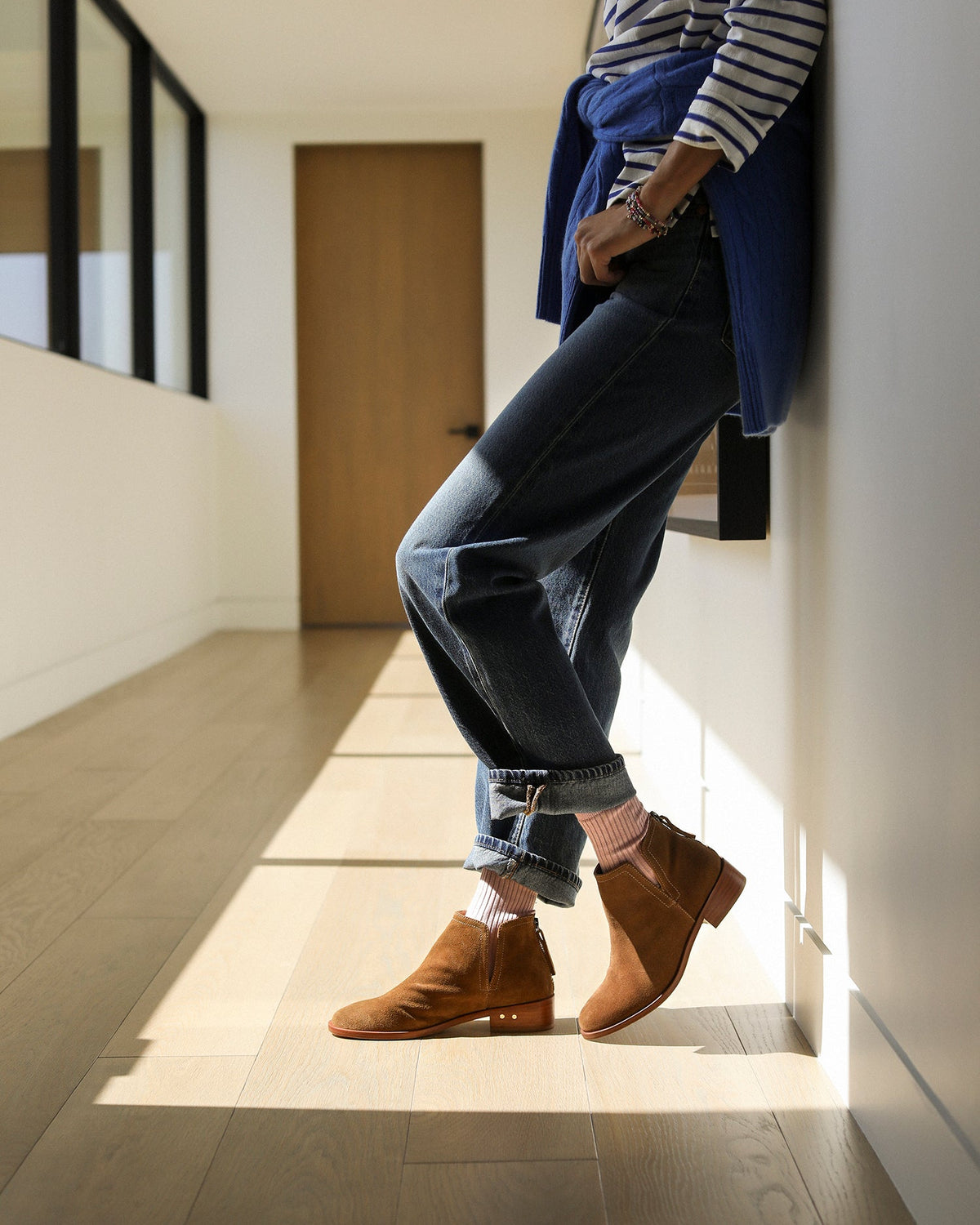 Woman wearing Falcon suede booties in chestnut with socks, jeans and striped shirt